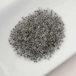 John Bead Cylin 11/0 Glow in the Dark Cylindrical Seed Beads - Grey, 25g sitting in dish