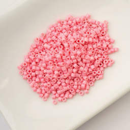 John Bead Cylin 11/0 Ceylon Cylindrical Seed Beads - Opaque Pink, 25g sitting in dish