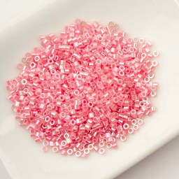John Bead Cylin 11/0 Ceylon Cylindrical Seed Beads - Crystal Rose Lined, 25g sitting in dish