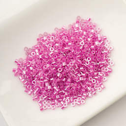 John Bead Cylin 11/0 Ceylon Cylindrical Seed Beads - Crystal Fuchsia Lined, 25g sitting in dish