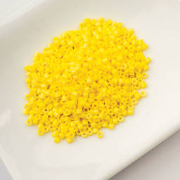 John Bead Cylin 11/0 Cylindrical Seed Beads - Yellow Opaque sitting in dish