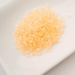 John Bead Cylin 11/0 Glow in the Dark Cylindrical Seed Beads - Light Yellow, 25g sitting in dish