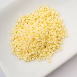 John Bead Cylin 11/0 Matte Macaron Cylindrical Seed Beads - Butter Cream sitting in dish