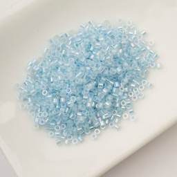 John Bead Cylin 11/0 Glow in the Dark Cylindrical Seed Beads - Blue AB, 25g sitting in dish