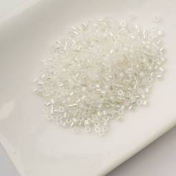 John Bead Cylin 11/0 Glow in the Dark Cylindrical Seed Beads - White to Turquoise AB, 25g sitting in dish