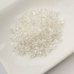 John Bead Cylin 11/0 Glow in the Dark Cylindrical Seed Beads - White to Sky AB, 25g sitting in dish