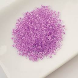 John Bead Cylin 11/0 Glow in the Dark Cylindrical Seed Beads - Purple, 25g sitting in dish