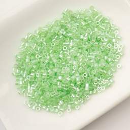 John Bead Cylin 11/0 Ceylon Cylindrical Seed Beads - Light Crystal Green, 25g sitting in dish