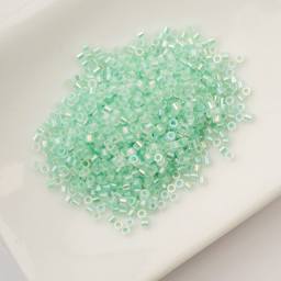 John Bead Cylin 11/0 Glow in the Dark Cylindrical Seed Beads - Green AB, 25g sitting in dish