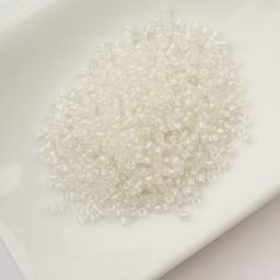 John Bead Cylin 11/0 Glow in the Dark Cylindrical Seed Beads - White to Green, 25g sitting in dish