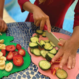Handstand Kitchen Cutting Board & Knife Set, fruits being cut on top of cutting board.