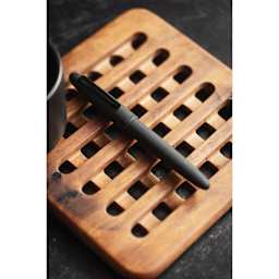 Esterbrook Estie Fountain Pen - Raven Matte Black, resting on wooden coaster