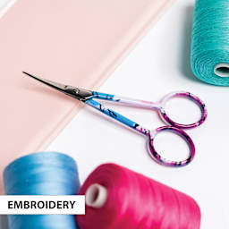 Singer Forged Embroidery Scissors, next to embroidery rolls