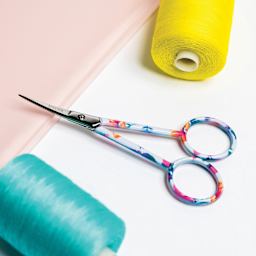 Singer Forged Embroidery Scissors - Floral next to thread spools
