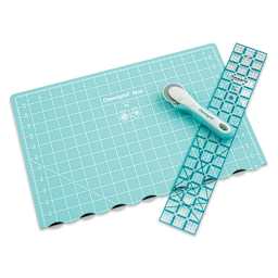Rotary cutter with large folded mat and ruler laid out