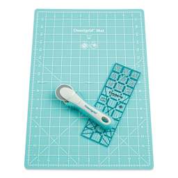 Rotary cutter with small unfolded mat and ruler laid out