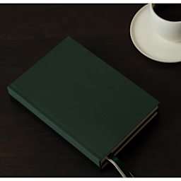 Gry Mattr Essential Linen Dotted Notebook - 5-3/4" x 8-1/2", Forest, laying on table