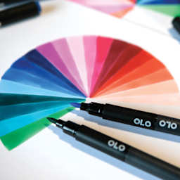 Olo Dual-Tip Markers, two brush markers laid out over drawing of a color wheel