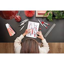 Artist using Pantone Color Guide and Pantone Dual Tip Markers to draw a still life.
