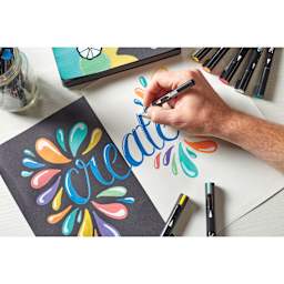 Sharpie Creative Acrylic Markers in hand, painting on light and dark surfaces