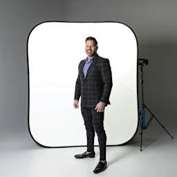 Savage High Key Freestanding Background - 6 ft x 7 ft in use as softbox background behind standing subject