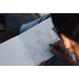 Etchr The Perfect Sketchbook (person drawing cats in sketchbook)