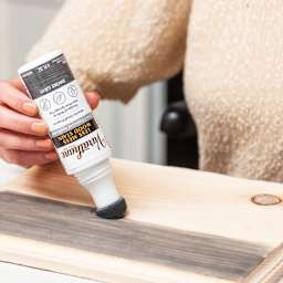 Person applying Varathane Less Mess Wood Stain in smoke to wooden board