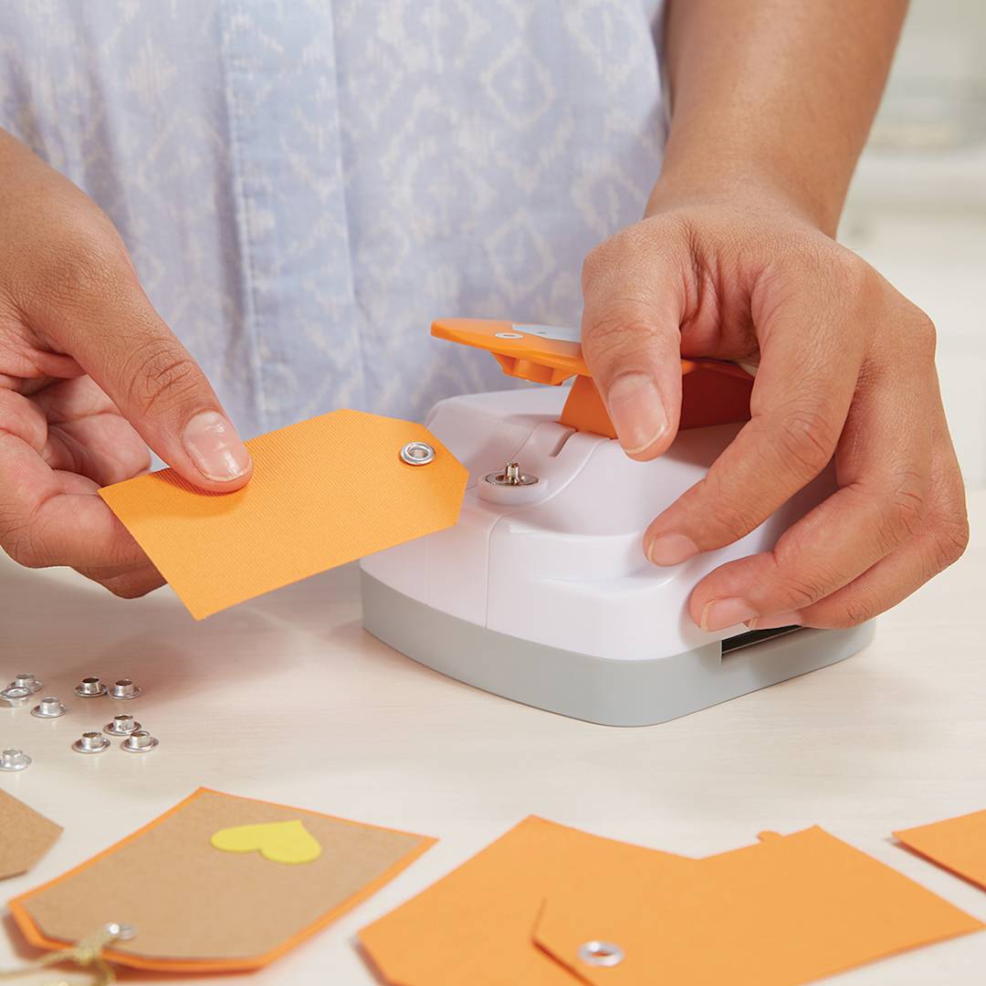 Open in modal - Fiskars Tag Maker - Closeup of person making eyelet hole on Tag
