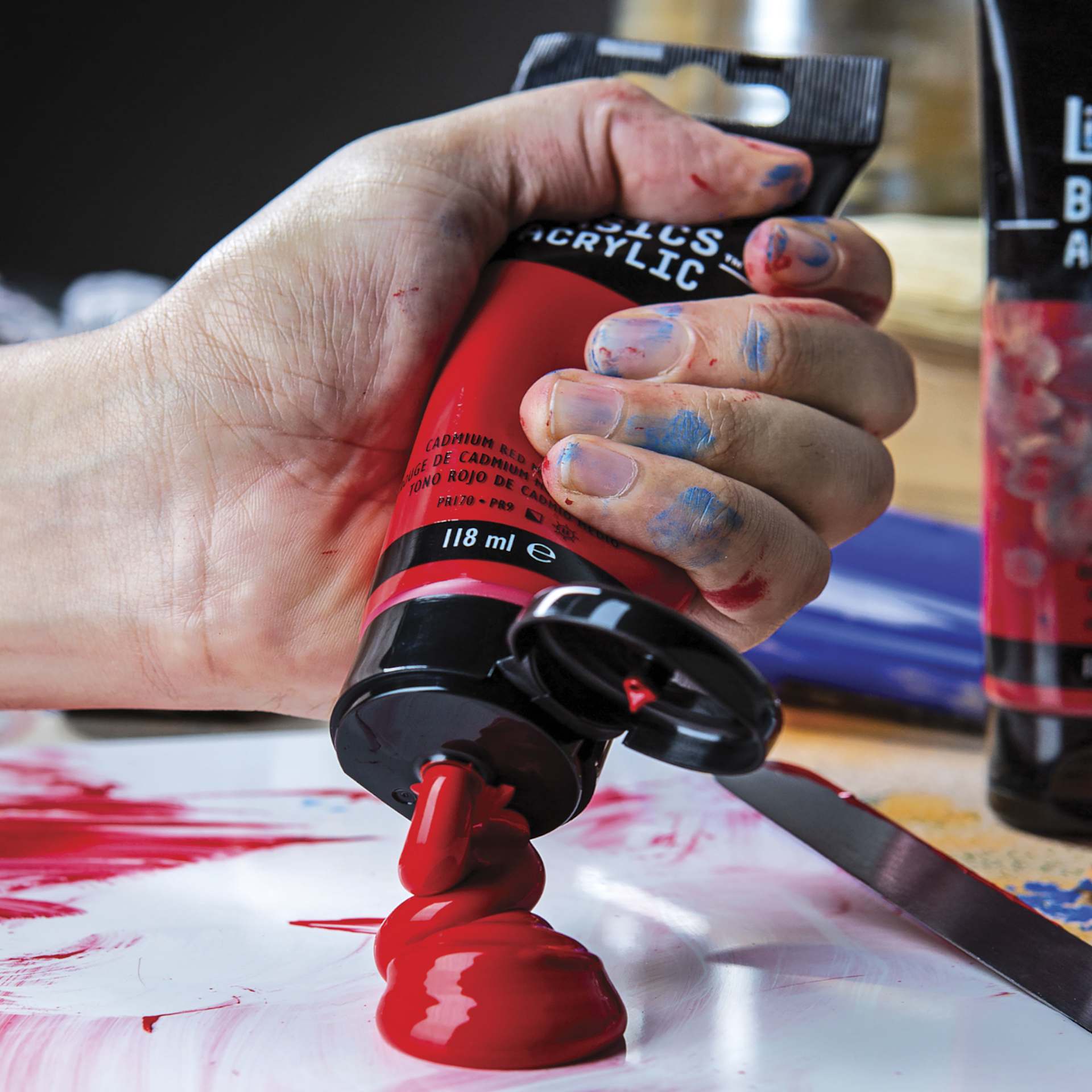 Red paint being squeezed from a tube onto a palette. Red paint being squeezed from a tube onto a palette.