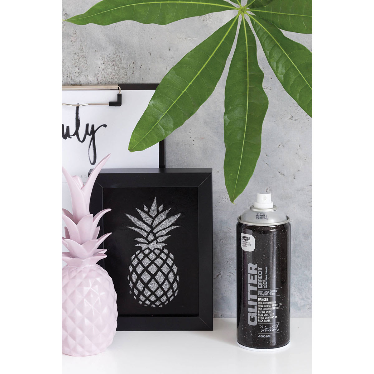 Montana Glitter Effect Spray Paint - Spray can next to framed Glitter pineapple artwork on black