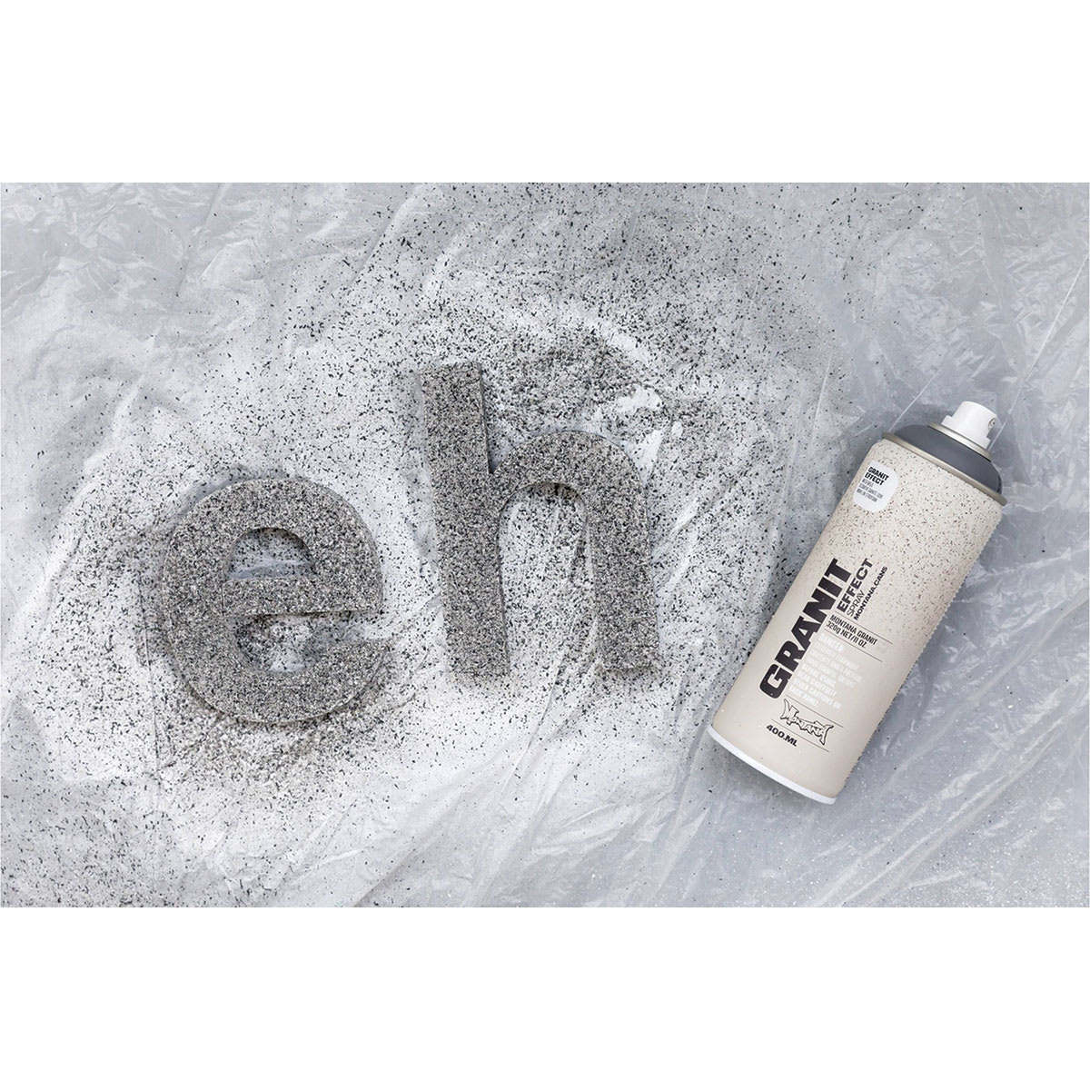 Montana Granit Effect Spray - can laying next to gray painted 3D letters Montana Granit Effect Spray - can laying next to gray painted 3D letters