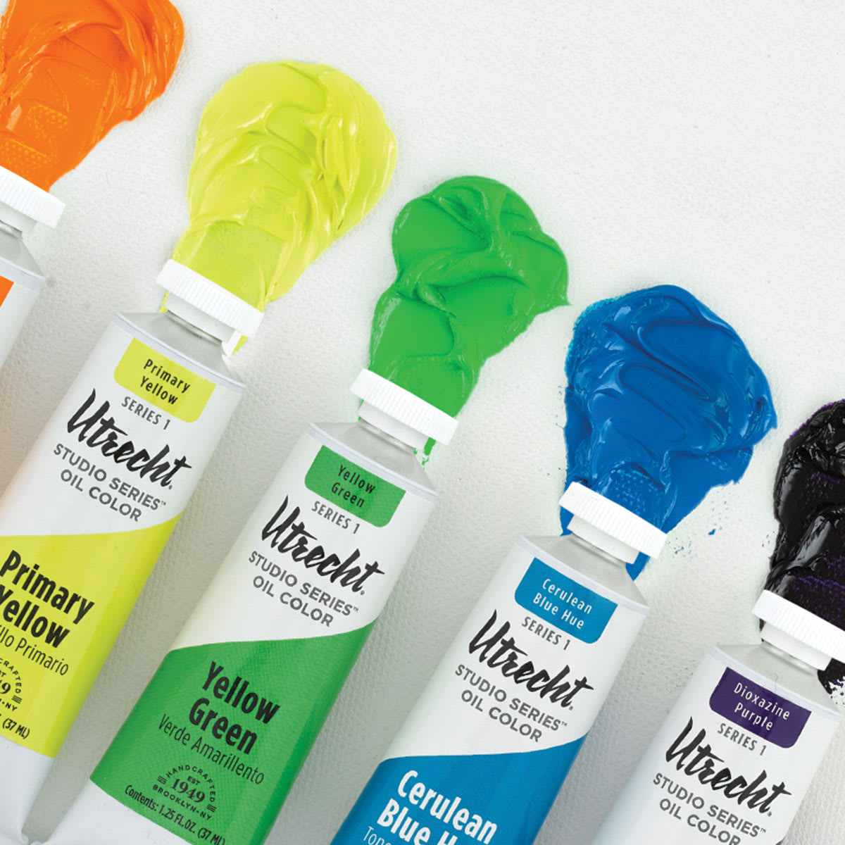 Utrecht Studio Series Oil Paints - Assorted Tubes laying on corresponding colors of wet paint 