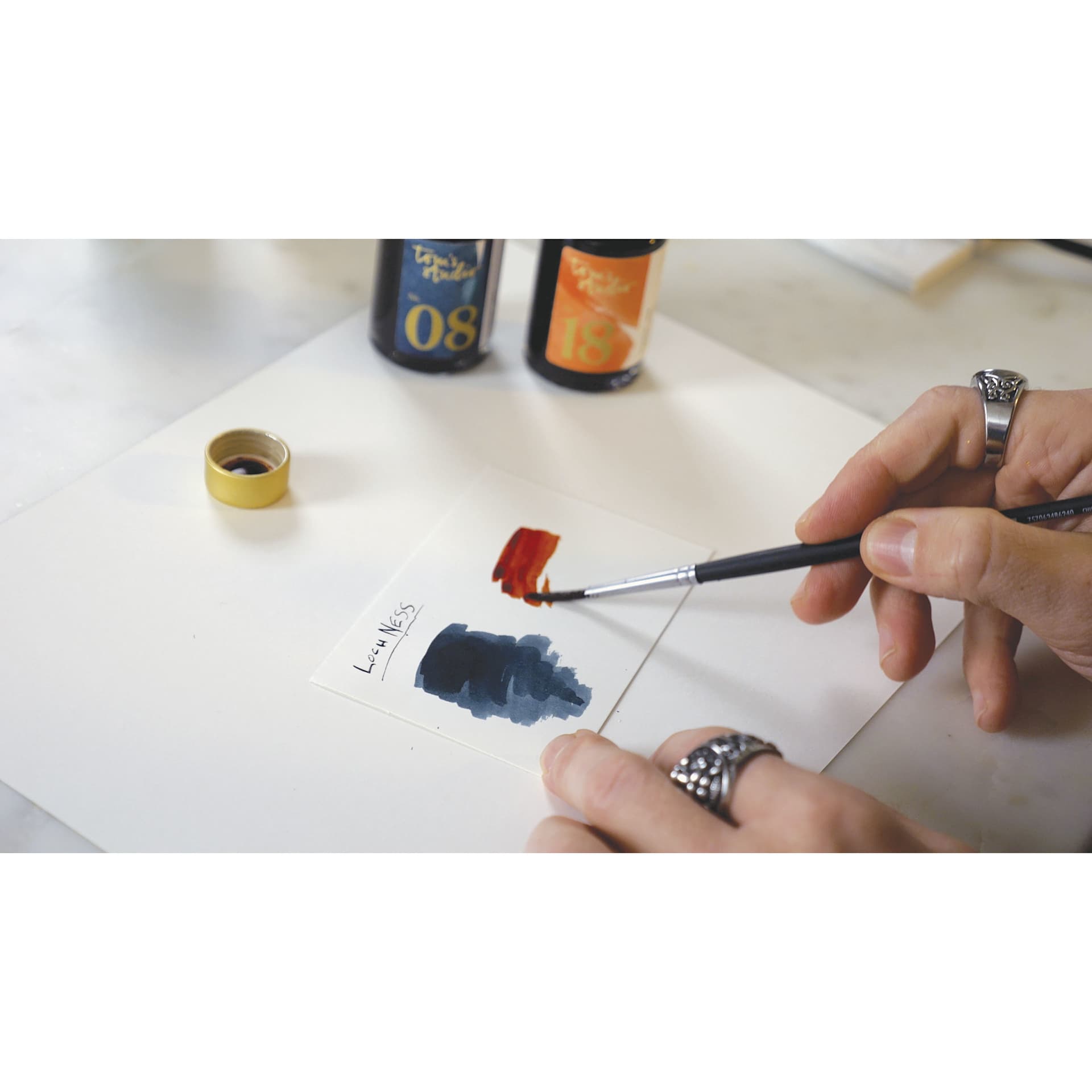Tom's Studio Fountain Pen Ink, brush in hand creating ink swatches for two colors