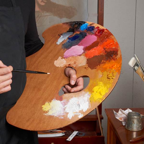 Painter holding Grand View Confidant style in left hand, with paint Painter holding Grand View Confidant style in left hand, with paint