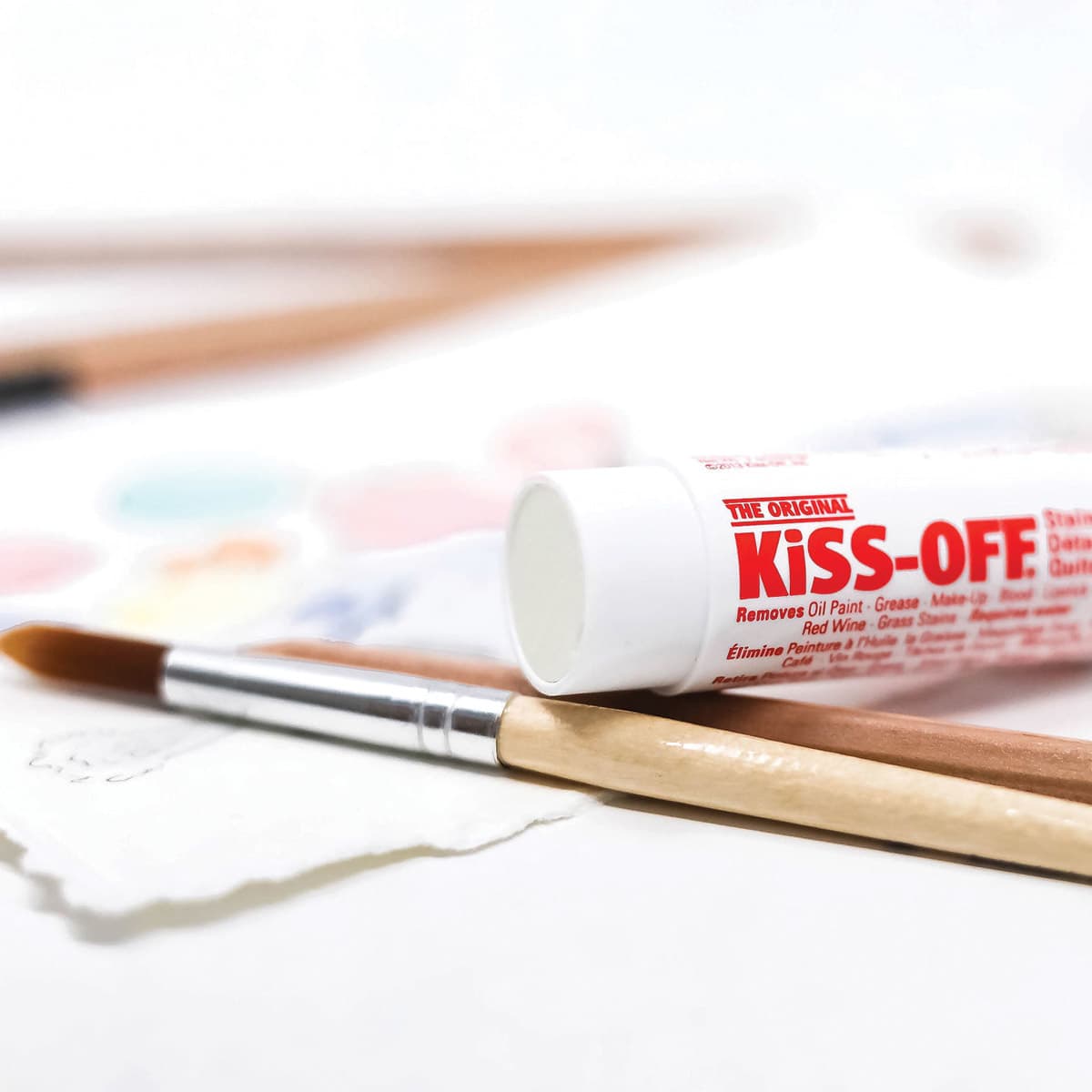 Kiss-Off Stain Remover - Closed tube of remover lying on paint brushes Kiss-Off Stain Remover - Closed tube of remover lying on paint brushes