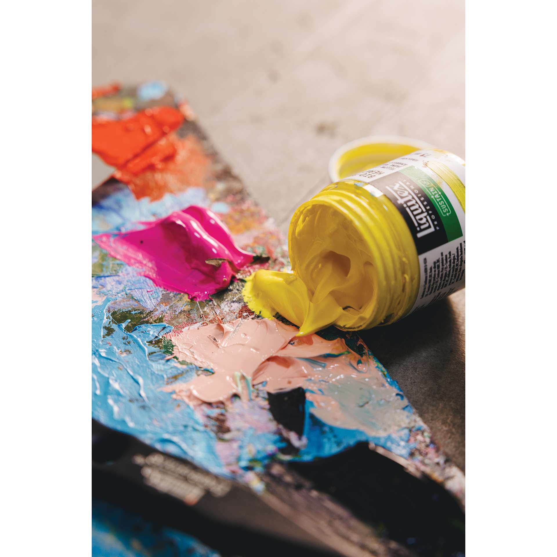 Yellow Liquitex Bio-Based Heavy Acrylic Paint jar on its side with paint on palette. Yellow Liquitex Bio-Based Heavy Acrylic Paint jar on its side with paint on palette.