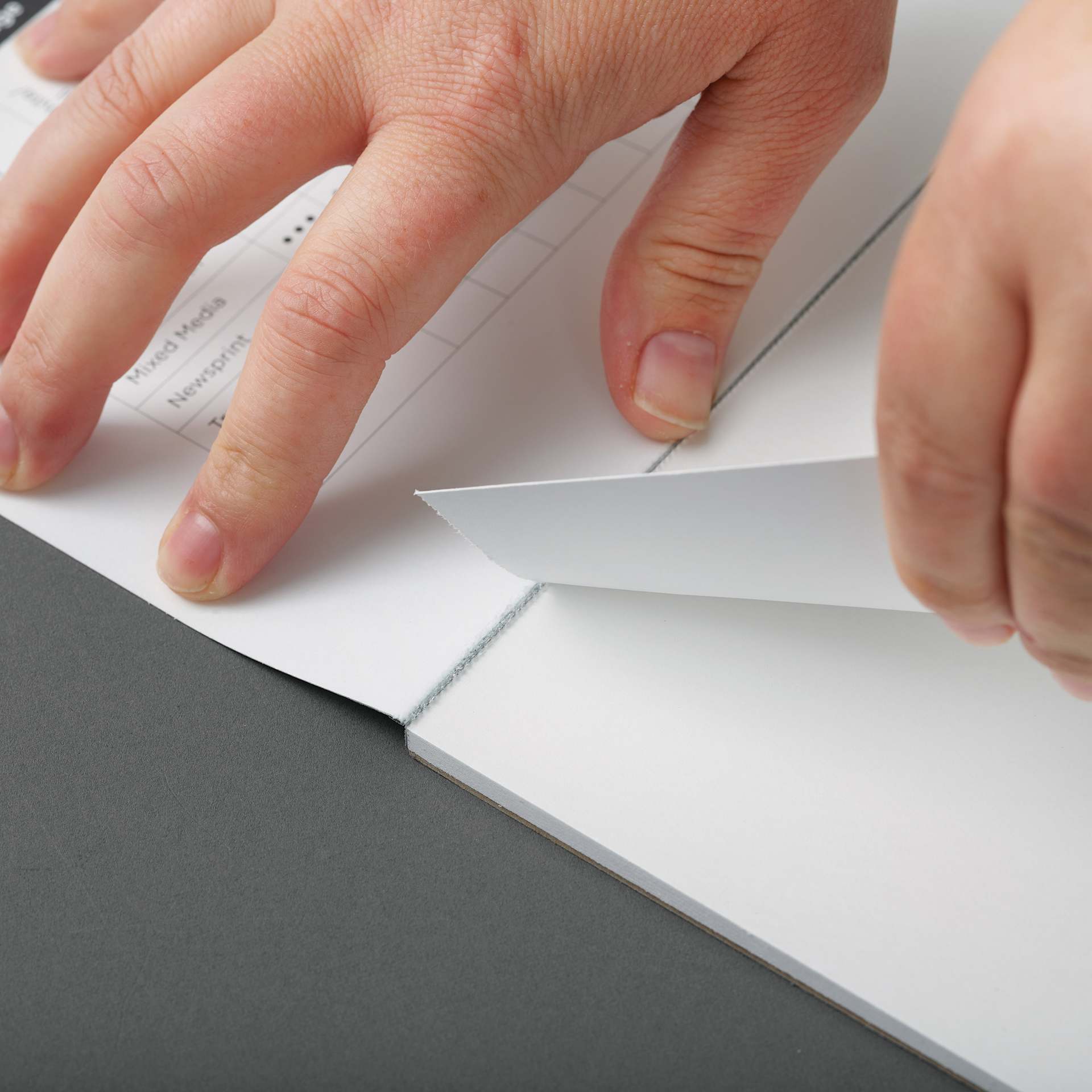 Blick Bristol Pad - 9" x 12", Smooth, 15 Sheets, in use, separating a sheet from the pad