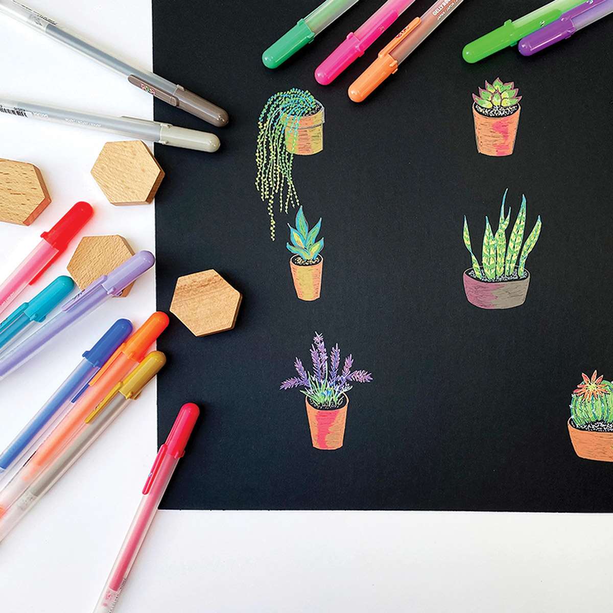 Sakura Gelly Roll Moonlight Pens - Cacti drawn on black paper with several pens lying nearby