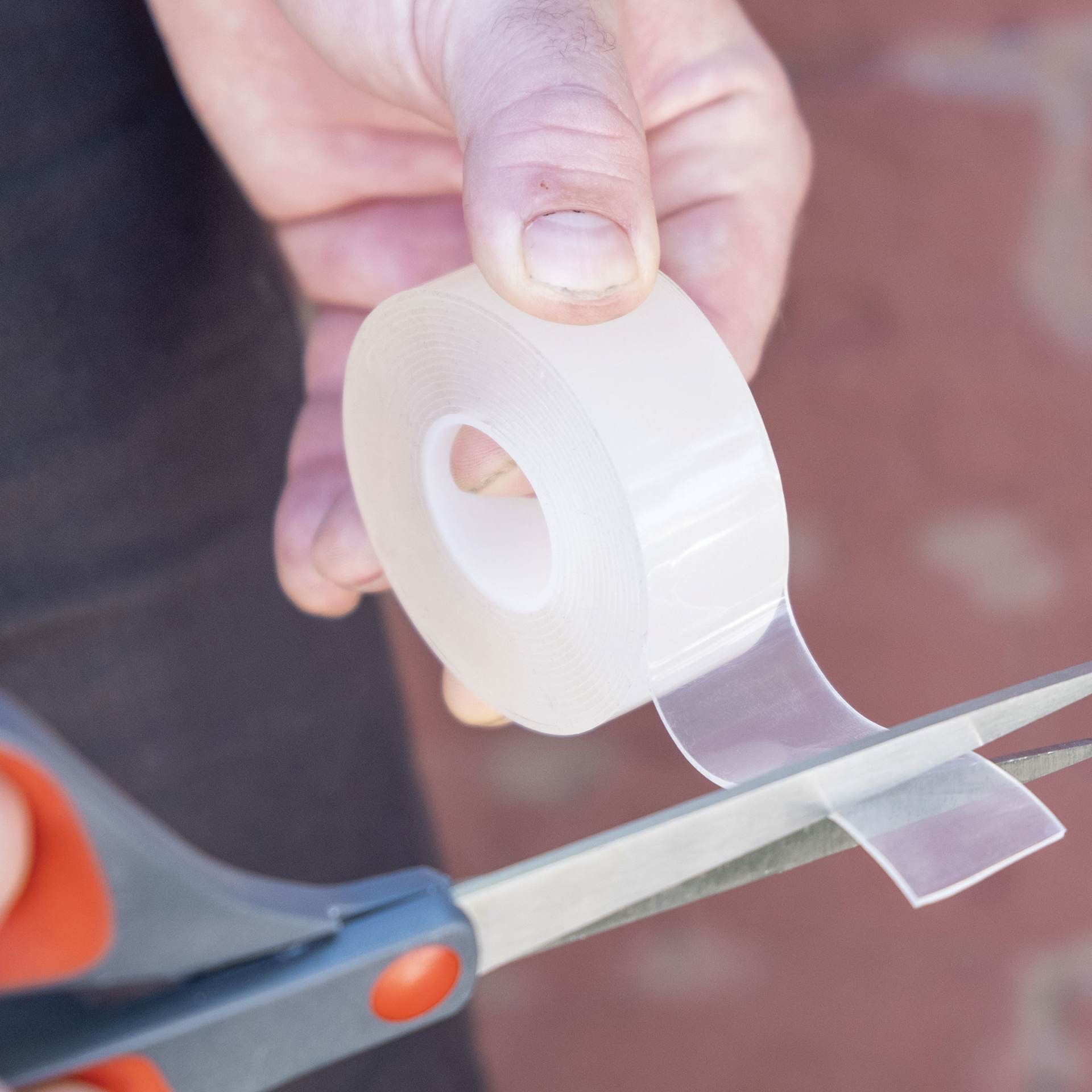T-Rex Strong and Clear Mounting Tape (Tape being cut with scissors)
