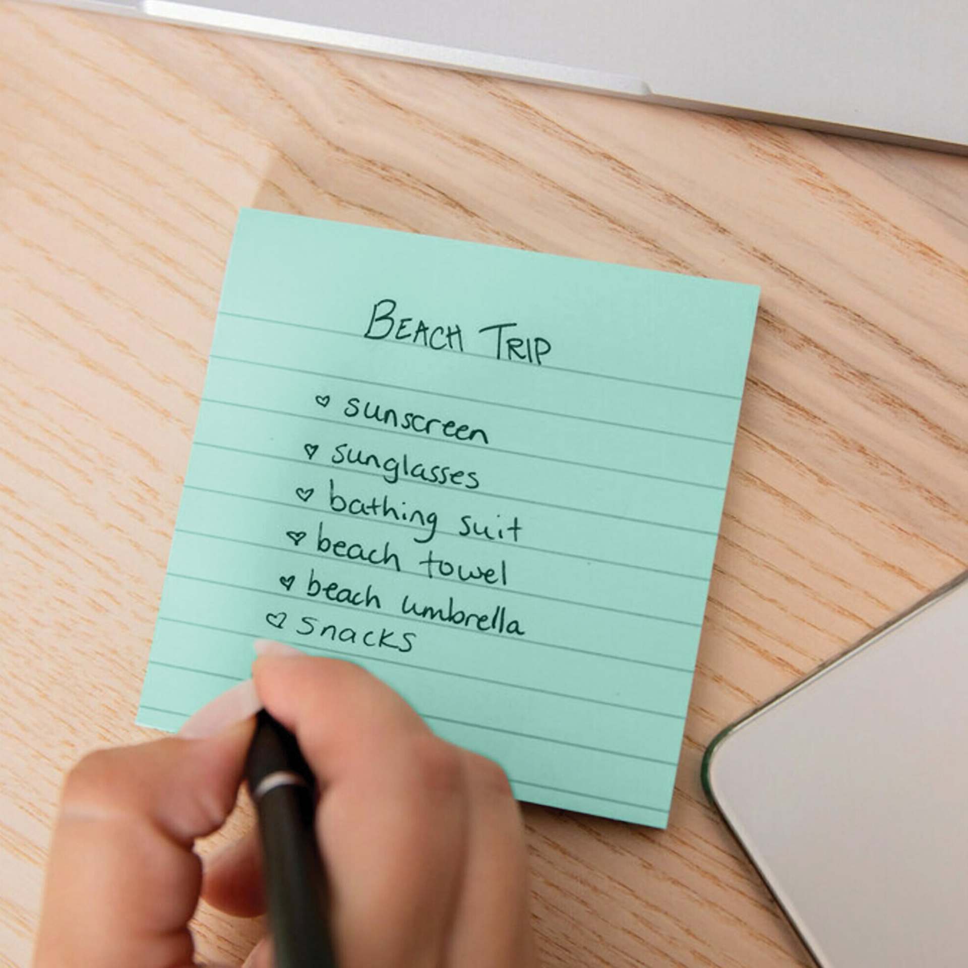 Post-it Recycled Super Sticky Notes - Pen in hand writing a list on lined note
