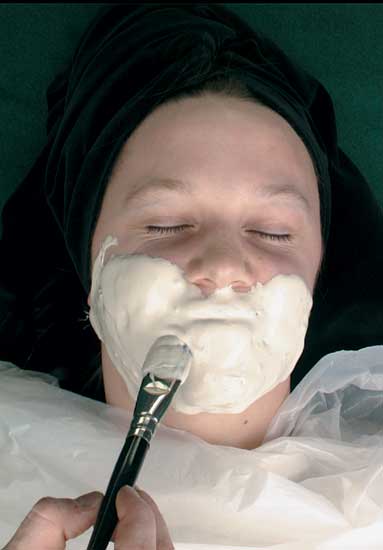 Moulage and Posmoulage Material - Material being applied to a face with brush
