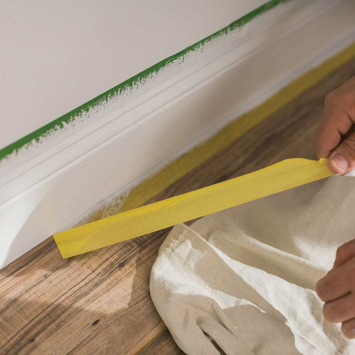 FrogTape Delicate Surface Painter's Tape - .94" x 60 yds Roll being removed from wooden floor