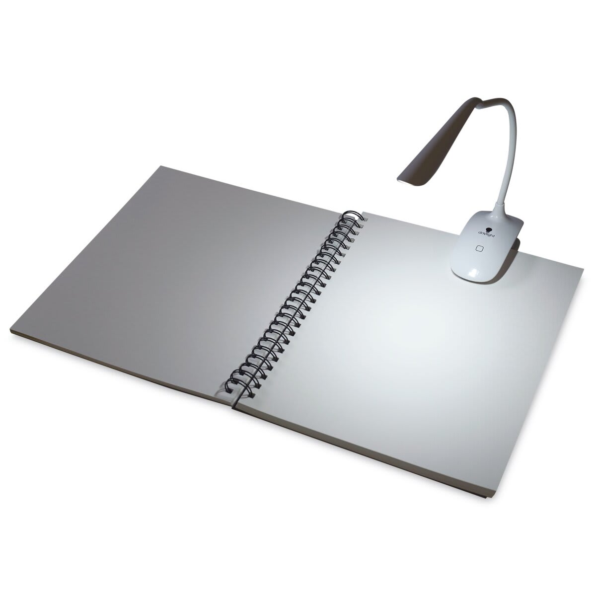 Daylight Smart Clip-On Lamp clipped on open sketchbook in dark space