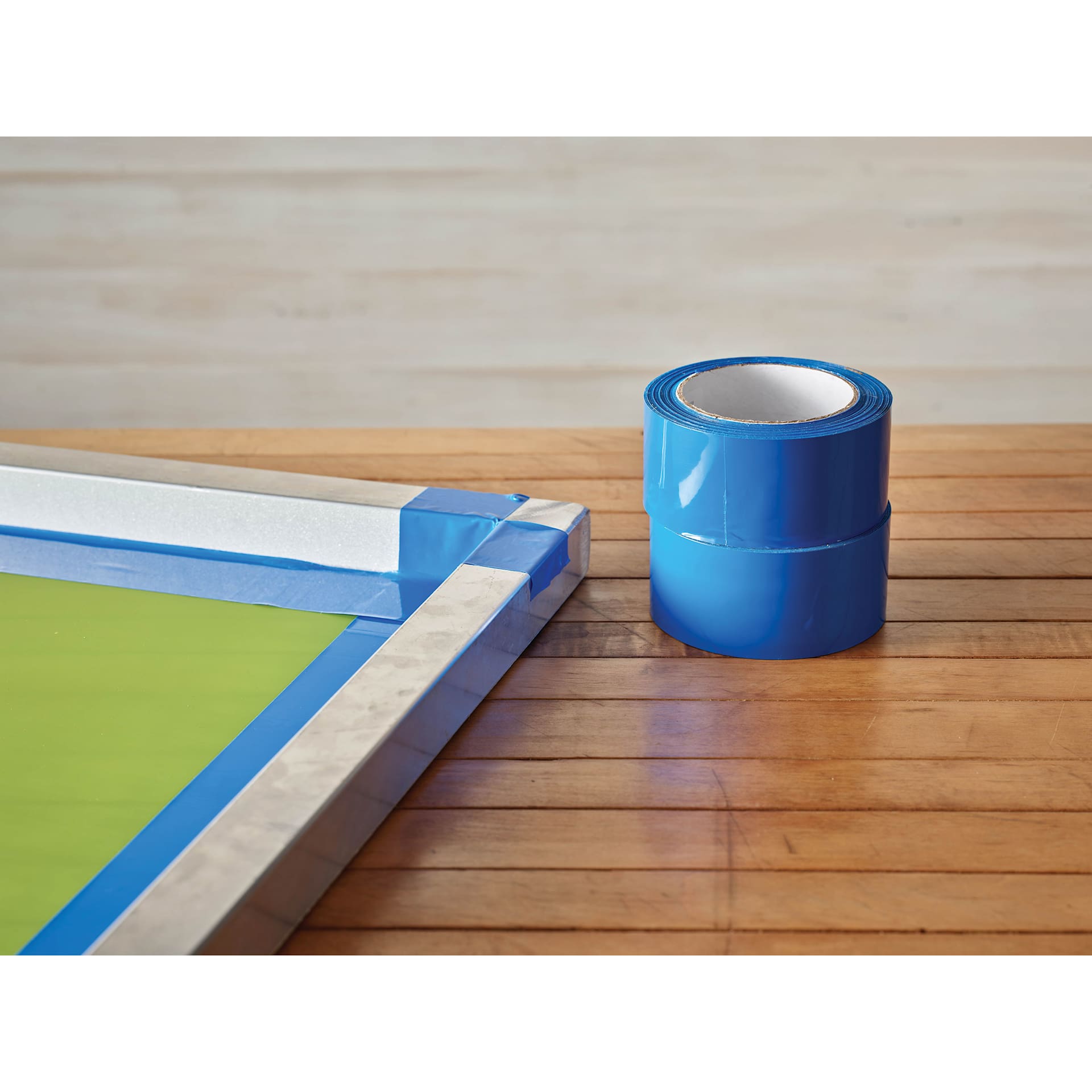 Speedball Block Out Tape - 2" x 36 yd rolls sitting beside screen