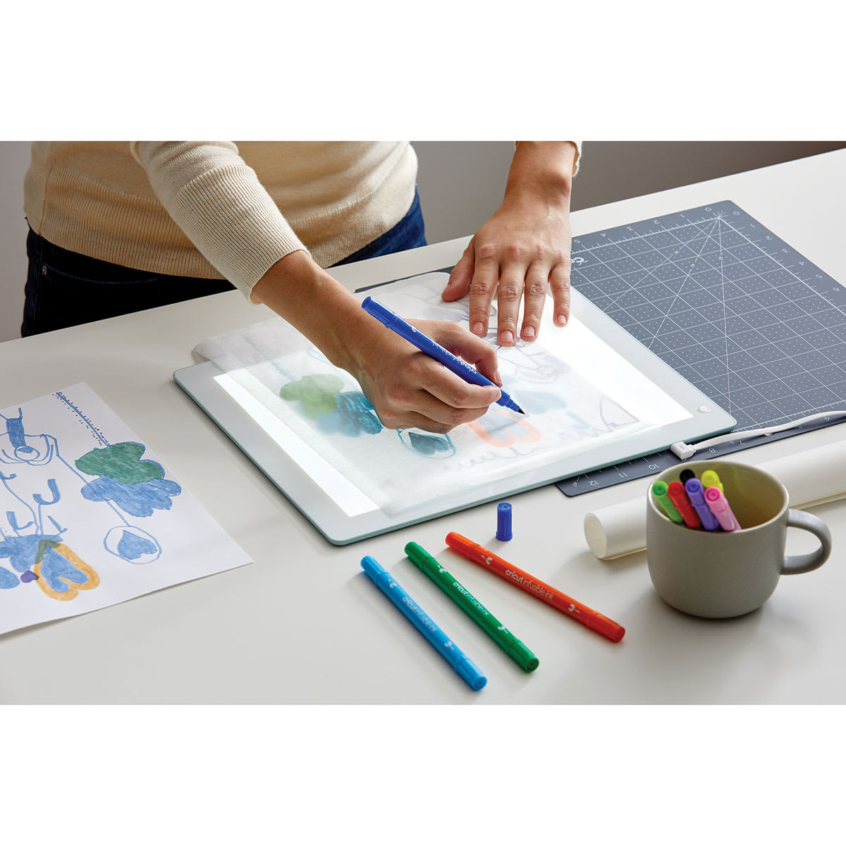 Cricut BrightPad - Mint, 13-1/2" x 11" (Person using BrightPad to trace image)