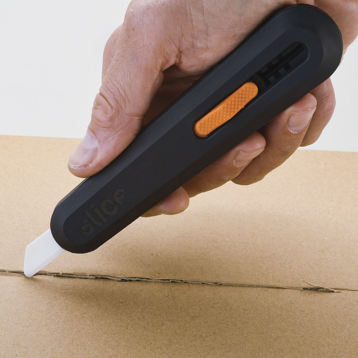 Slice Manual Utility Knife - Hand using Knife to open a package