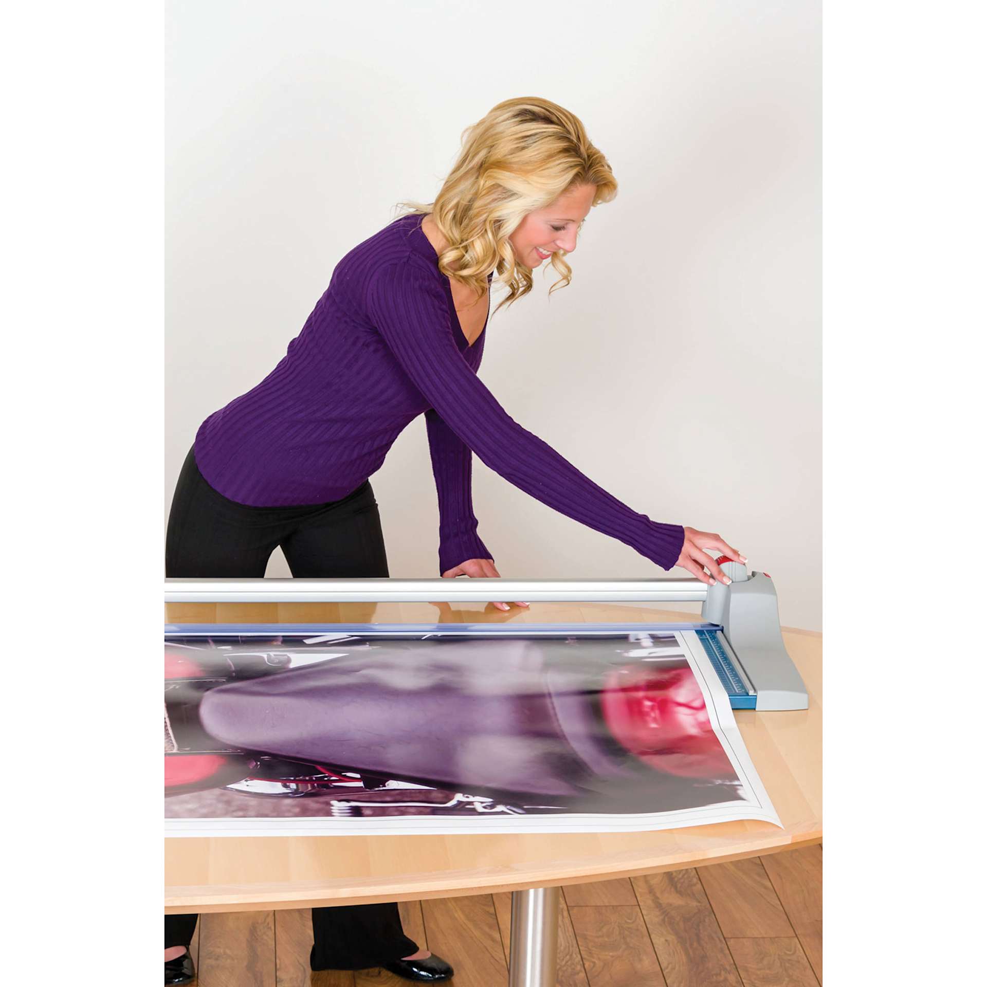 Dahle Premium Rotary Trimmer - 36" Cutting Length, adult pulling blade over a poster on top of a table Dahle Premium Rotary Trimmer - 36" Cutting Length, adult pulling blade over a poster on top of a table