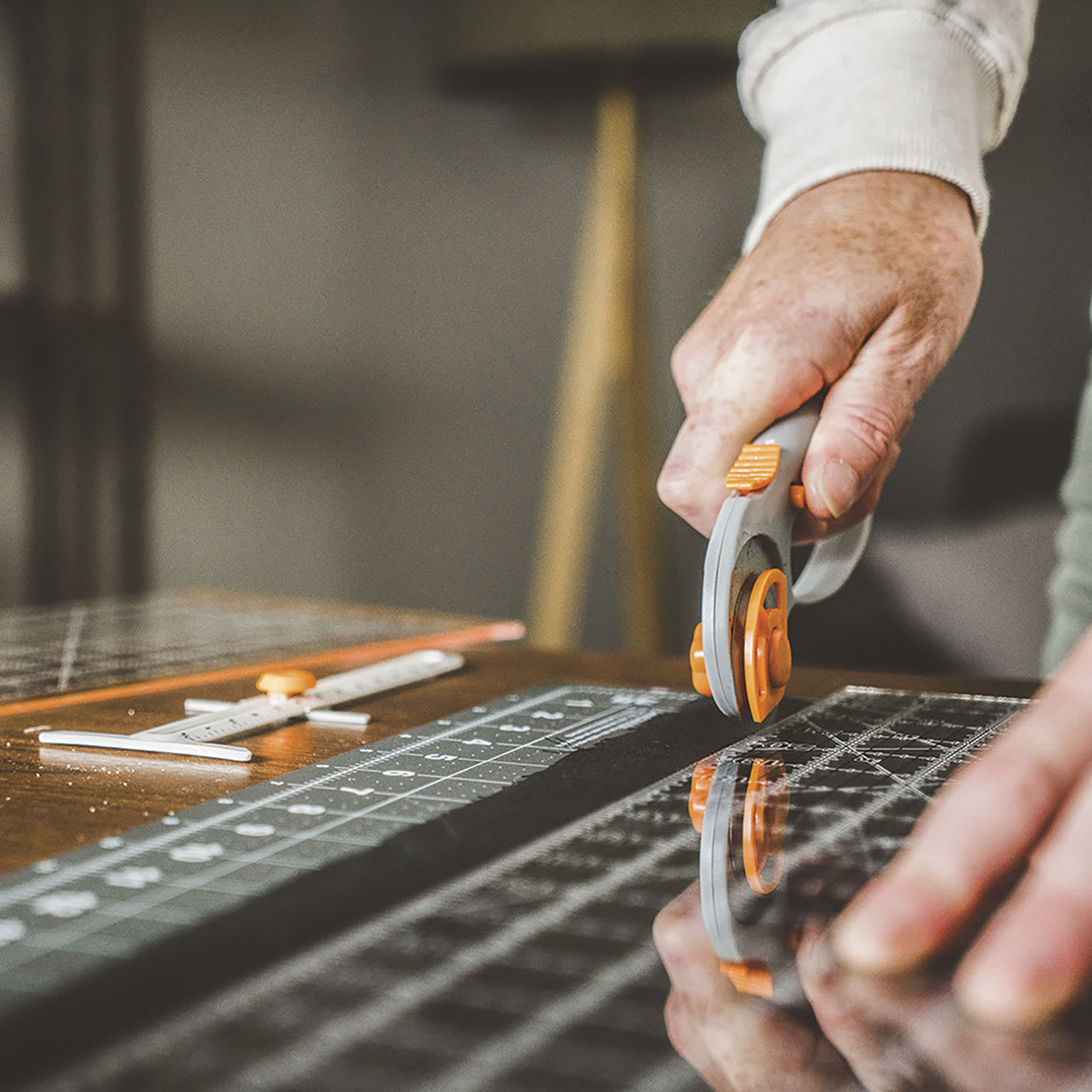 Fiskars Comfort Loop Rotary Cutter - Closeup of Tool cutting material along an edge