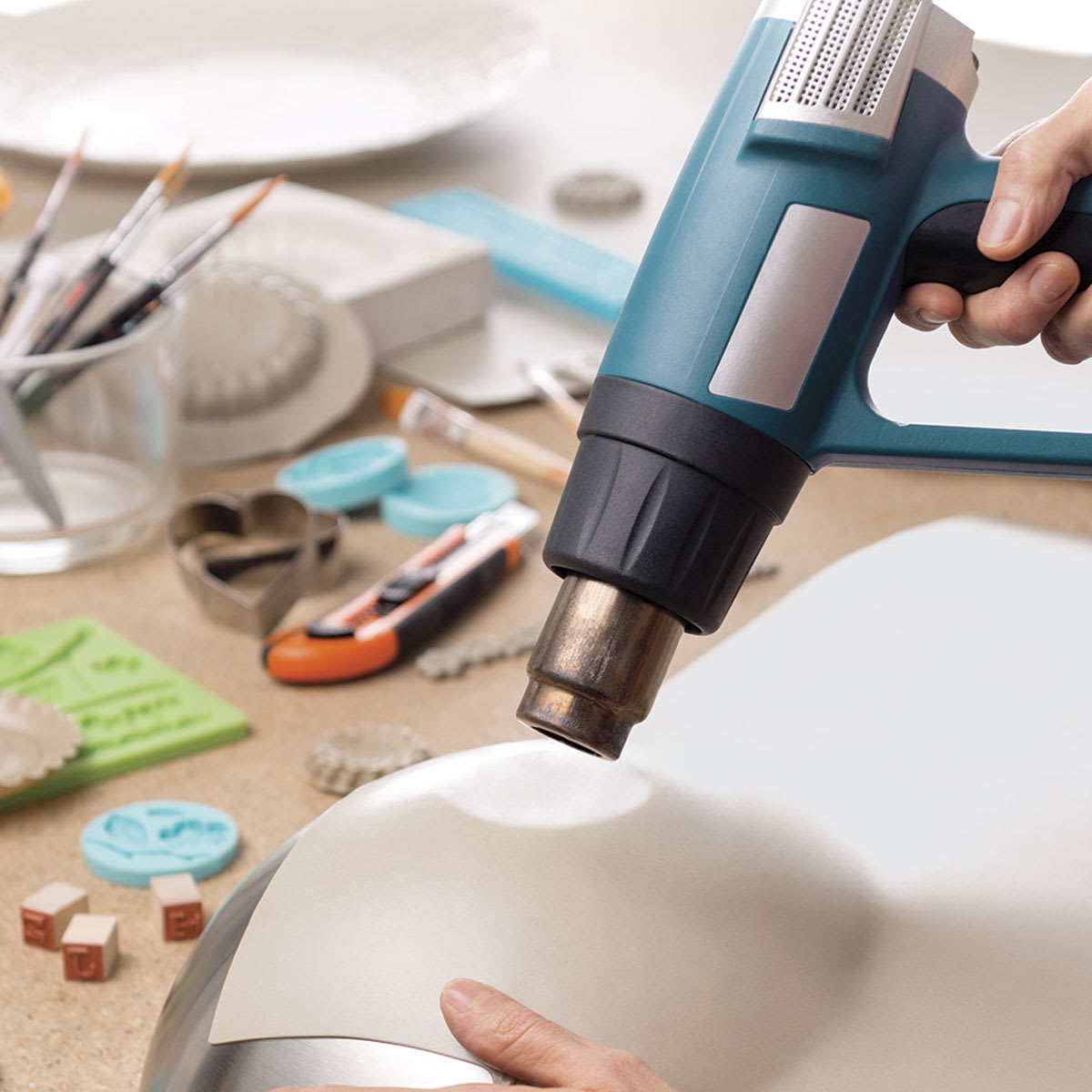 Thibra Fine Sculptable Plastic - Person making plastic pliable with Heat Gun