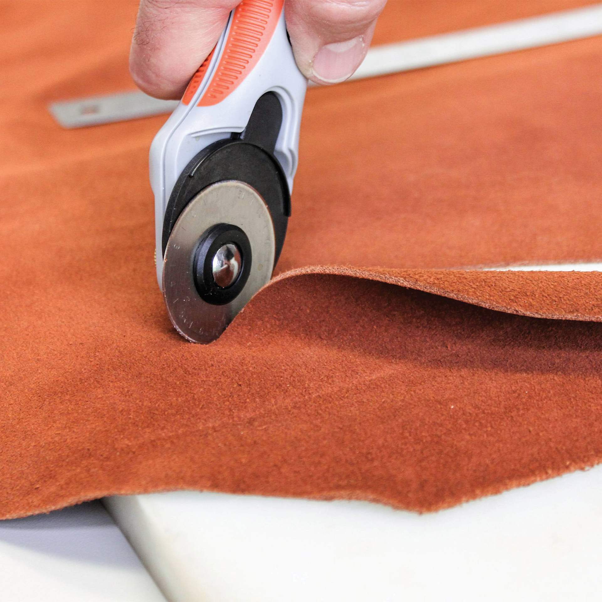 Realeather Leather Rotary Cutter, hand using blade on fabric
